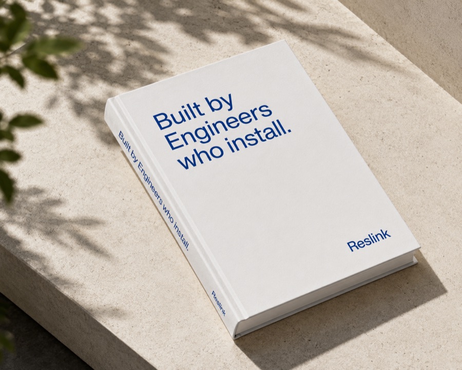 A white hardback titled "Built by Engineers who install" resting on a stone ledge