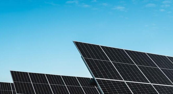 Tilted solar panel rows against a clear blue sky