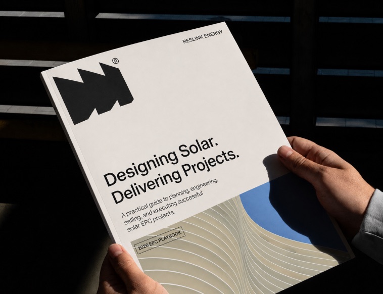 Hands holding a printed booklet titled Designing Solar, Delivering Projects