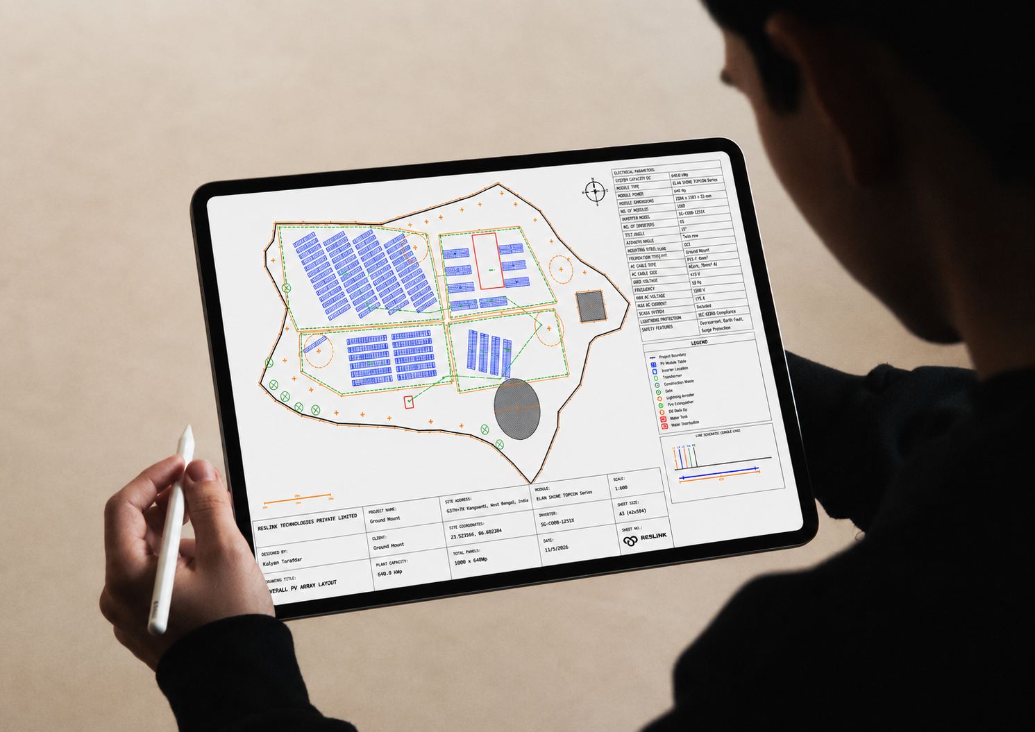 Engineer reviewing a PV array layout drawing on a tablet