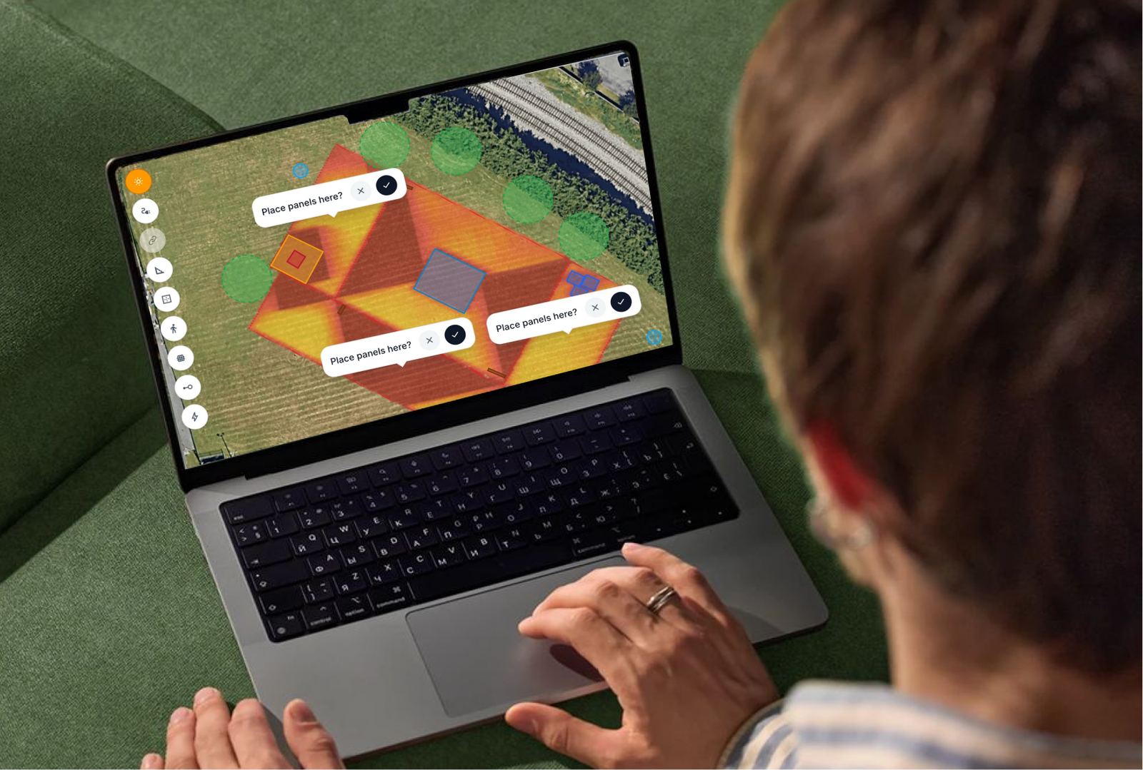 Designer placing solar panels on a 3D roof model on a laptop